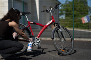 Utilisation du spray ABNET Proflash pour nettoyer le pédalier et le cadre d'un vélo avant l'hivernage.