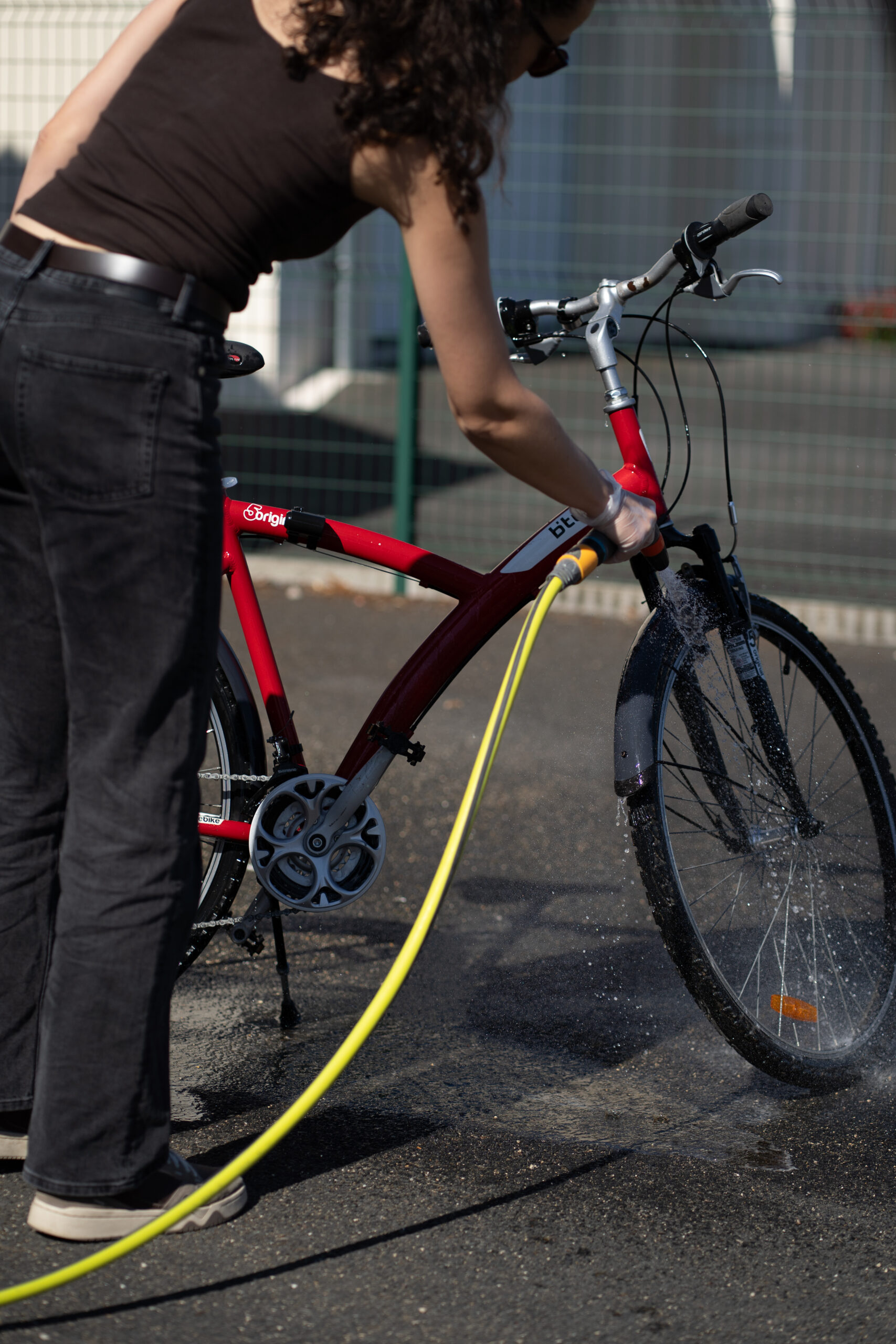 Rinçage à l'eau claire d'un vélo après l'application du dégraissant ABNET Proflash pour l'hivernage.